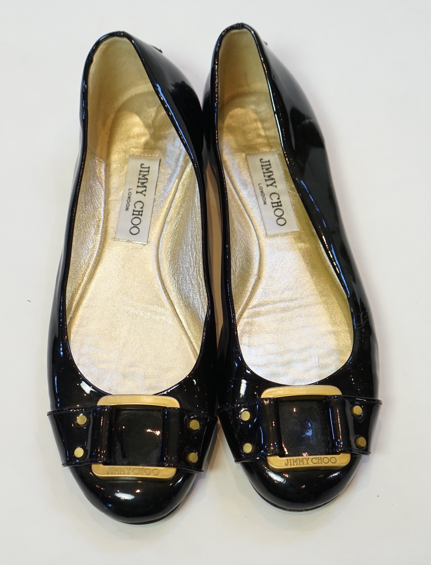 A pair of Jimmy Choo lady's black patent leather pumps with gold buckle, size EU 39